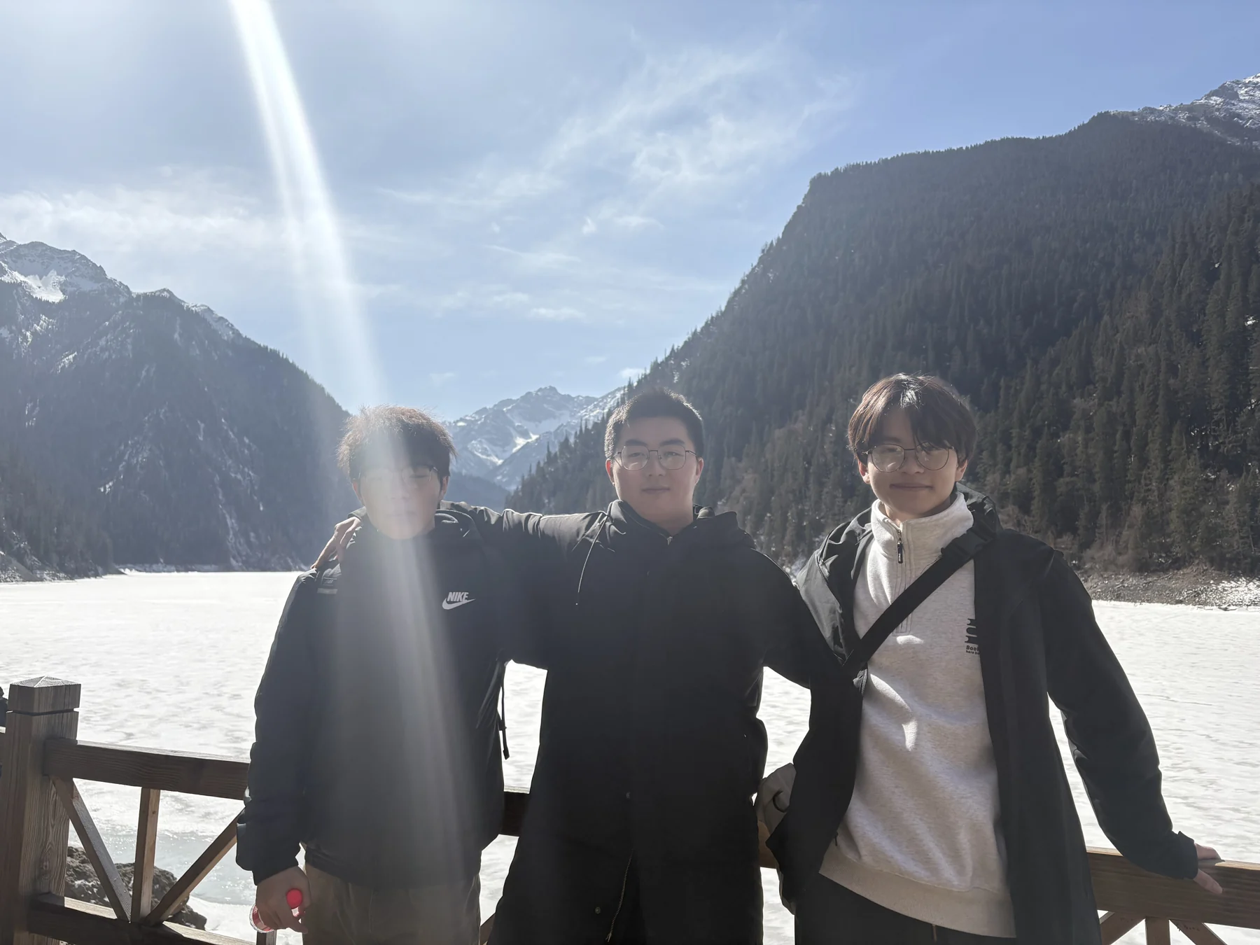 三位大学室友站在雪山与湖边合影