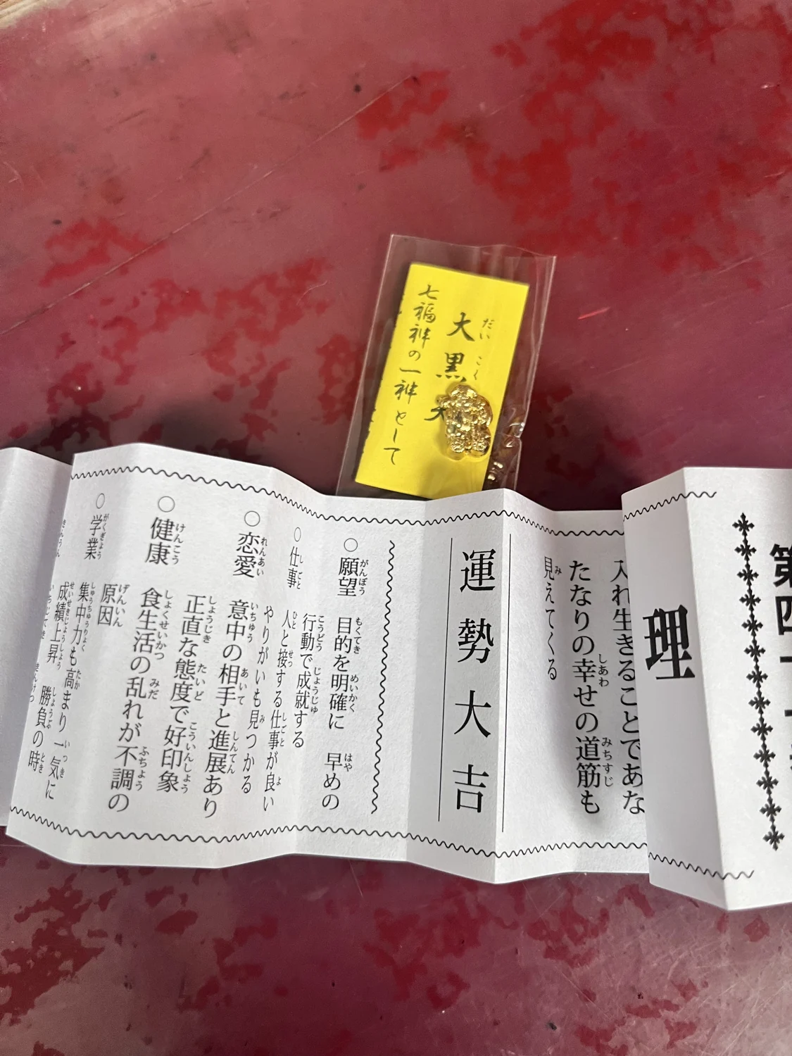 红色桌面上展开的御神签与黄色纸签