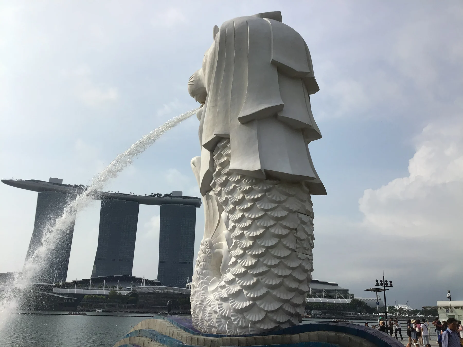 喷出水柱的鱼尾狮与身后的海湾景色